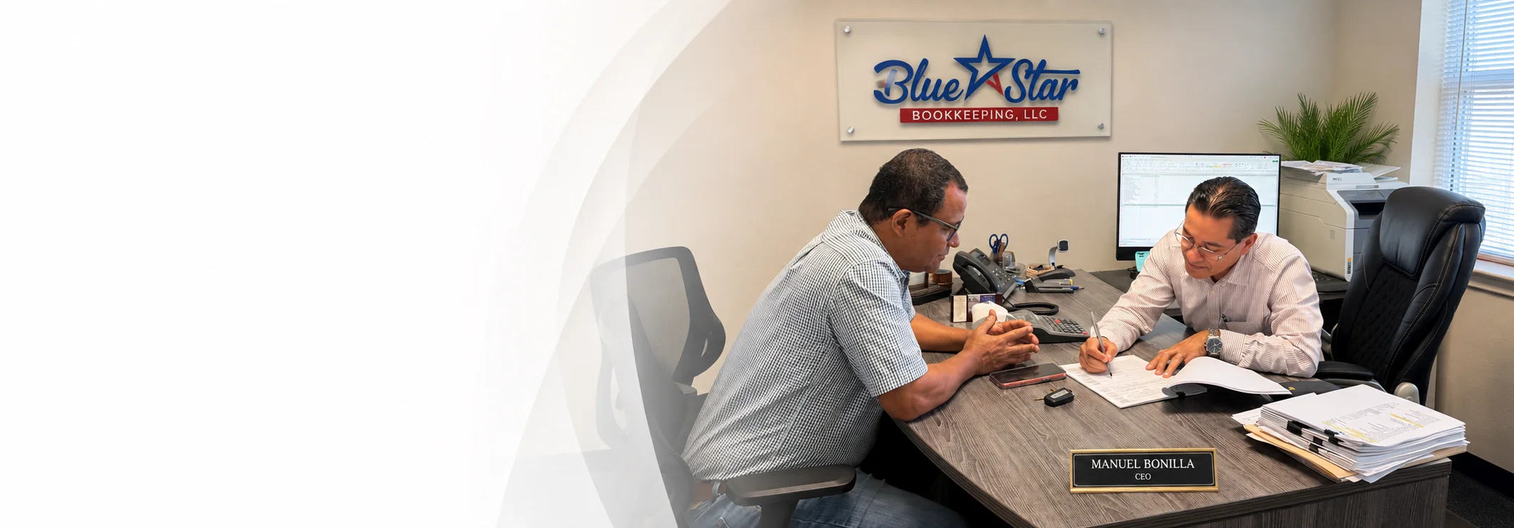 Blue Star Bookkeeping owner Manuel Bonilla helping a client in the Austin office